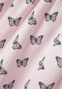 Ljust rosa tyg med ett upprepande mönster av svarta fjärilar, med texturerade diamants- och linjeaccenter genom hela materialet.
