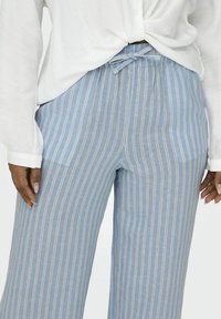 Lichtblauwe gestreepte wijde broek met een elastische tailleband en trekkoord. De stof heeft een zachte, gestructureerde afwerking met contrasterende witte strepen.