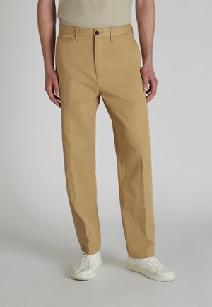 Khaki chinos with a straight fit, made of smooth cotton fabric, featuring a front pocket, belt loops, and a black button at the waist.