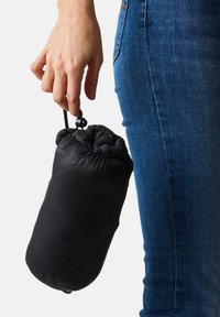 Sacca nera imbottita tenuta da una mano, con chiusura a coulisse e una superficie liscia, di forma cilindrica per facilitarne il trasporto.