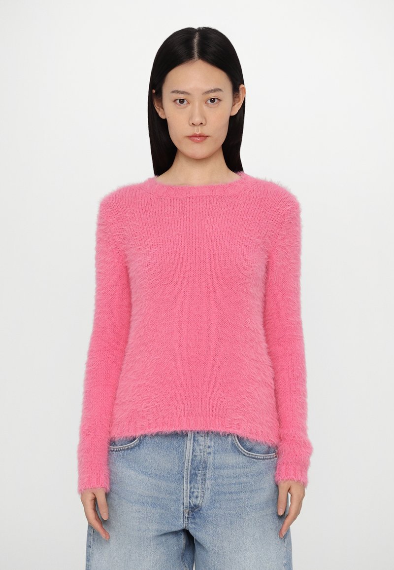 Suéter esponjoso de mangas largas en un brillante color rosa. Presenta un cuello redondo y un corte holgado, con detalles acanalados en los puños y en el dobladillo.
