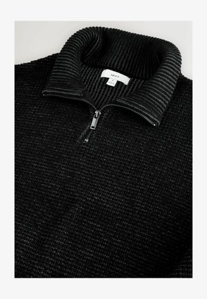 Czarny sweter na zamek z teksturowanym wykończeniem i prążkowanym kołnierzem. Wyróżnia się centralnym zamkiem oraz metką widoczną wewnątrz kołnierza.