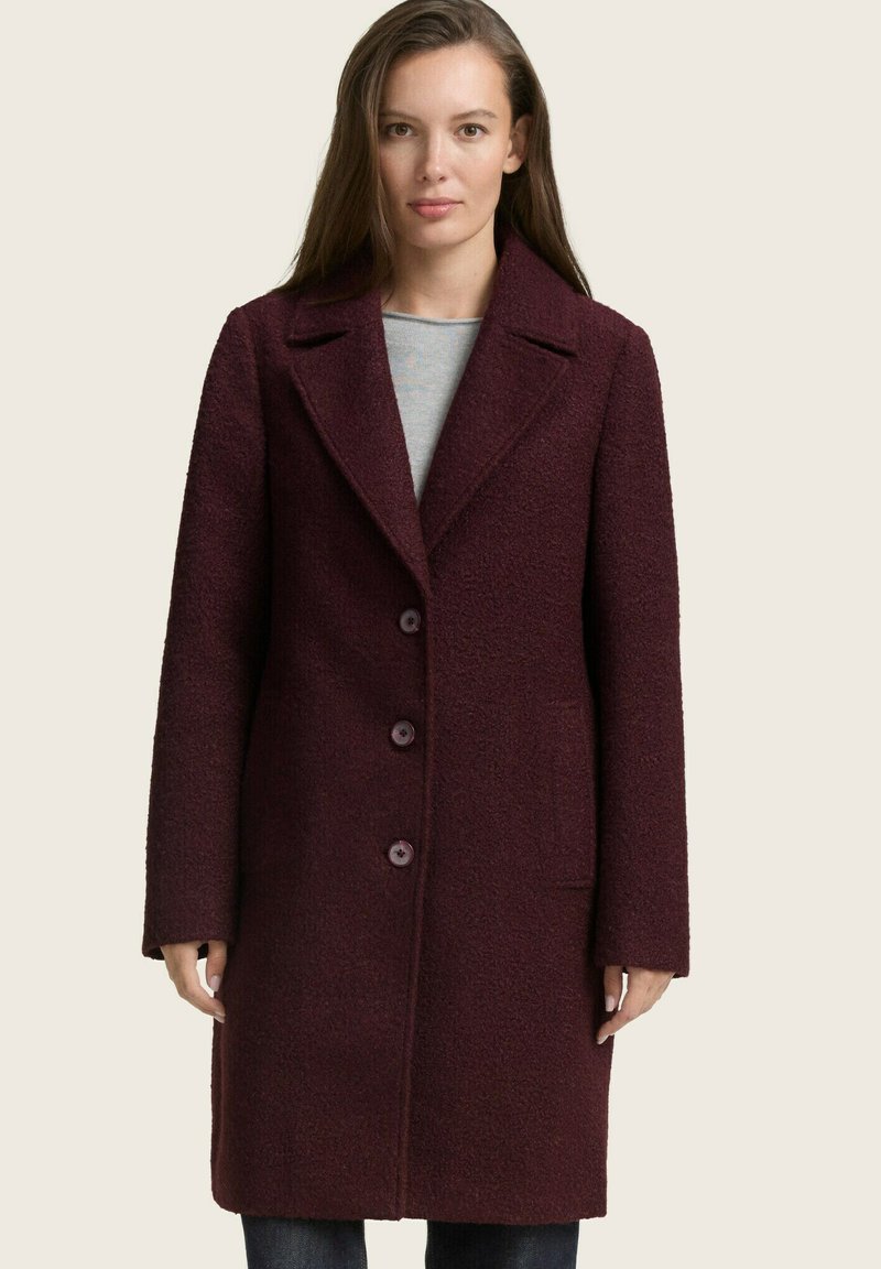 Burgunderfarbener Wollmantel mit strukturierter Oberfläche, einreihigem Design, Reverskragen, vier Knöpfen und seitlichen Taschen.