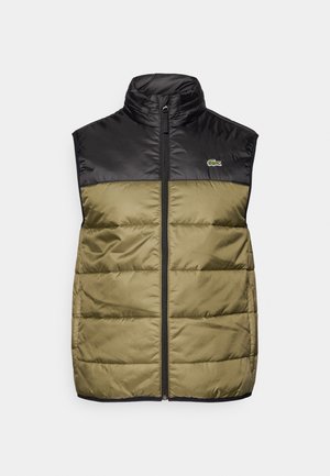 Puffervest med svart topp og olivengrønn bunn. Har høy krage, frontglidelås og en liten logo på venstre bryst.