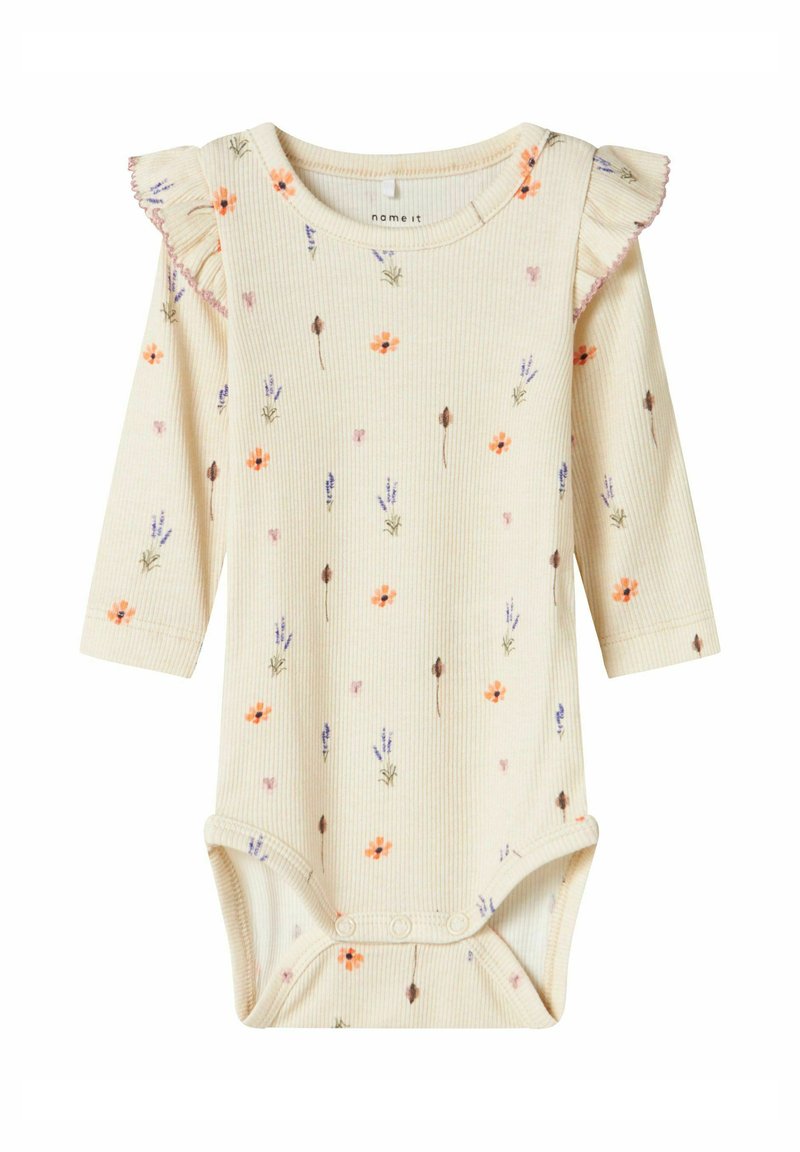 Cream ribbed long-sleeve baby bodysuit with floral patterns, ruffled shoulder detail, snap closure at the bottom, and soft texture.