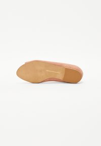 Rosa Wildlederschuh mit runder Spitze und einer tanfarbenen Gummisohle. Die Innensohle ist mit Markenlogo versehen. Glatte Textur, minimalistisches Design.