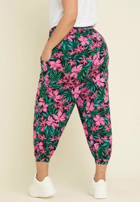 Blommiga joggerbyxor i svart, med rosa blommor och gröna blad. Elastisk midja och mudd. Sidofickor ingår.