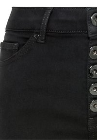 Primer plano de pantalones negros con lazos de cinturón, bolsillo frontal y botones metálicos en el lado derecho abrochados verticalmente.