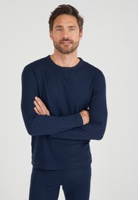 Navyblauwe sweatshirt met lange mouwen, een ronde halslijn, geribde manchetten en een relaxte pasvorm. Gemaakt van een textiele katoenmateriaal.
