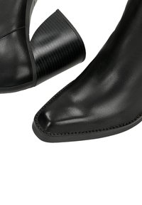 Černé kožené kotníkové boty s špičatou špičkou, se strukturovaným černým blokovým podpatkem a švy podél okraje. Minimalistický design.