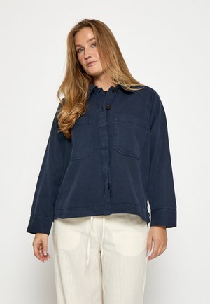 Mørkeblå button-up jakke med to brystlommer, lange ærmer og en cropped kant. Lavet af et tekstureret stof med en krave.