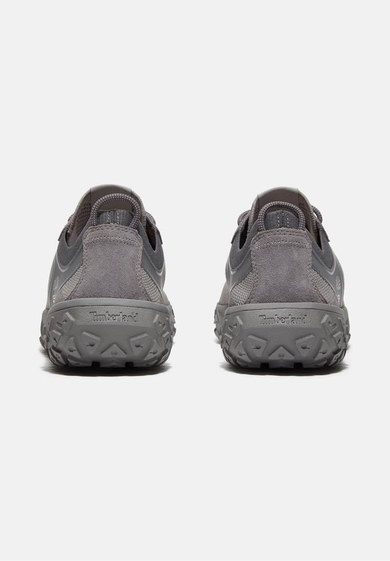 Par de zapatillas Timberland grises con suelas texturizadas, detalles de ante y malla, y tiradores en la parte trasera, vistas desde atrás.