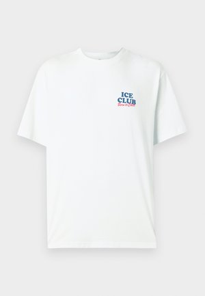 T-shirt blanc à manches courtes avec texte bleu et rouge "ICE CLUB Born to Chill" sur le côté gauche de la poitrine, col rond, design uni.