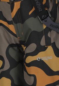 Camouflage pants featuring a blend of black, green, tan, and orange colors. Adjustable belt with "ZIGZAG" logo, visible stitching details.
