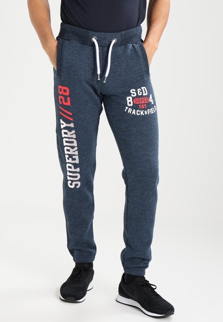 Marineblauwe sweatpants met een zachte textuur, voorzien van witte en rode bedrukte tekst op het linkerbeen en een drawstring tailleband.