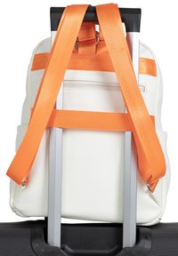 Weißer Rucksack mit orangefarbenen Tragegurten, der an einem schwarzen Koffergestänge befestigt ist. Er hat eine strukturierte Oberfläche und eine Reißverschlusstasche auf der Rückseite.