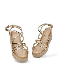 Sandalias de cuña espadrille con tiras doradas y un acolchado en la planta. Las tiras metálicas suaves se cruzan por el empeine.