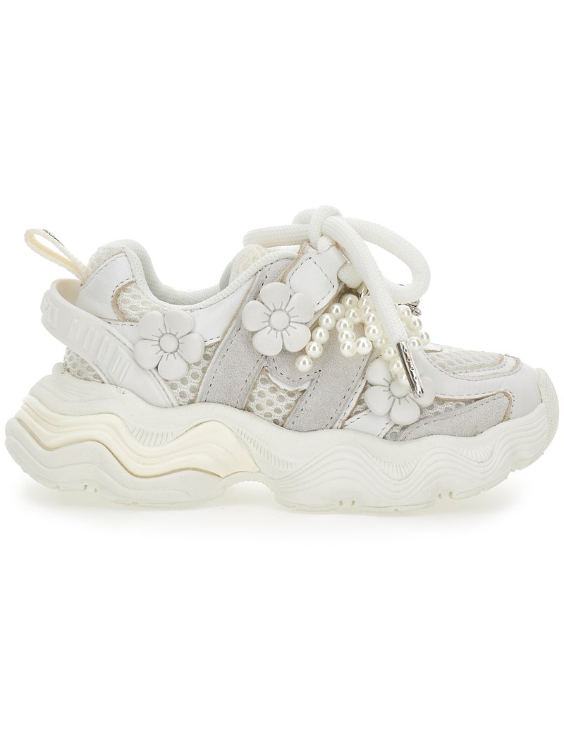 Bílá robustní teniska s panely z prodyšné síťoviny a semiše, zdobená květinovými aplikacemi a shluky perlových korálků na tkaničkách.