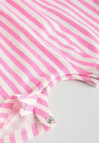 Roosa-valgete triipudega lühikeste varrukatega riideese puuvillast, millel on presskinnitused ja pehme tekstuur, ümmarguse kaelusega.