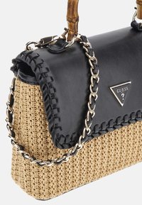 Haut en cuir synthétique noir avec bord tressé, corps en paille tissée, chaîne en or, anse en bambou, accent de logo triangle à l'avant.