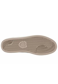 Kenkäpohja, jossa on beige kumi, ja joka sisältää sekoitetun kuvion, jossa on kalanruotokuvio ja pyöreitä tekstuureja. Keskellä logo, kaarevat reunat ja urat.