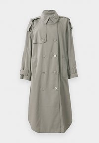 Trench coat doppiopetto in tessuto grigio chiaro, presenta tasche frontali, spalline sulle spalle e manicotti arrotolati. Texture liscia.