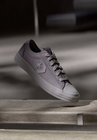 Light purple sneaker with a suede upper, rubber sole, and a star detail. Features six eyelets and round toe with textured accents.