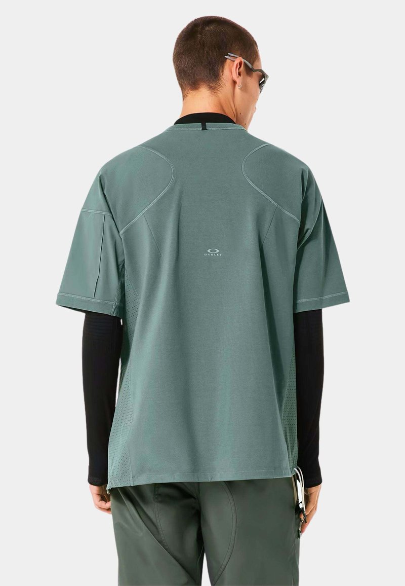 T-shirt de sport à manches courtes, vert menthe, avec une texture en mesh respirant sur les côtés, un col rond et un logo au dos.