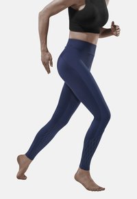 Dunkelblaue Leggings aus dehnbarem Material, mit einem hohen Taillenbund und einem Diamantmuster im Knöchelbereich. Entwickelt für aktive Bewegungen.
