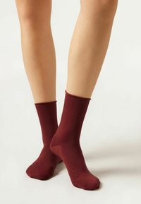 Bordeauxfärgade bomullsblandade crew-sockar med ribbstickade muddar, slät yta, knähöjd och sömlös tådesign.