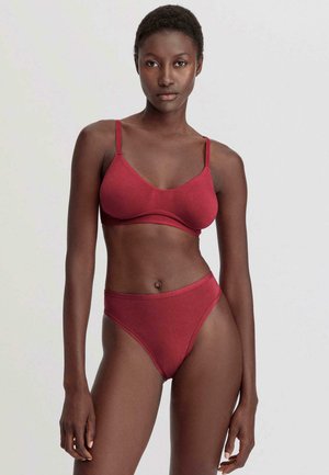 Bordeaux katoenen beha en hoog uitgesneden panties. Gladde textuur, subtiele glans, verstelbare bandjes en een naadloos ontwerp.
