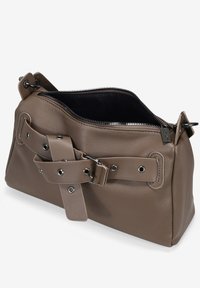 Bolso de mano de cuero marrón con forma estructurada, que cuenta con un cierre de cremallera, una correa decorativa con ojales metálicos y una textura suave.