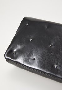 Clutch in pelle nera con una finitura lucida, caratterizzato da decorazioni in metallo argentato a forma di stelle, cuori e sfere sulla superficie.