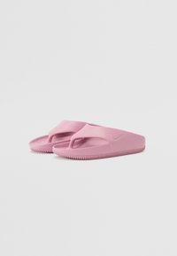 Rosa flip-flops med en glatt plastdesign, med en tåpost og strukturert innersåle, som sitter på en rillet yttersåle for grep.