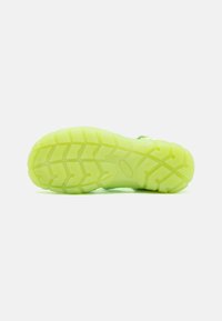 Neon-grüner Sneaker-Sohlen mit einem strukturierten Gummidesign und tiefen Profilmustern für verbesserten Grip und ein leichtes Gefühl.