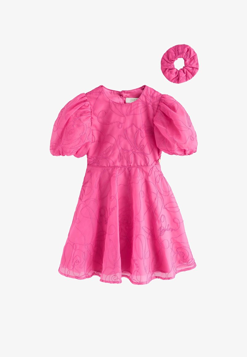 Bright pink toddler dress with puffed short sleeves, floral pattern stitching, and matching scrunchie hair accessory.