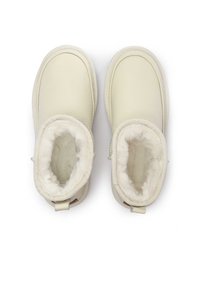 Baltas ādas zābaki ar mīkstu sintētiskā kažoka oderi. Noapaļots dizains, šuvju akcenti un vilkšanas cilpas aizmugurē, lai viegli uzvilktu.