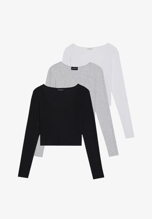 Trois hauts à manches longues en noir, gris et blanc, avec des décolletés en V et un design court. Fabriqués en tissu doux et léger.