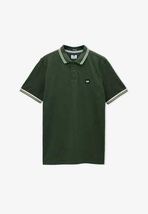 Tamsiai žalia polo marškinėliai su baltomis juostelėmis ant apykaklės ir rankogalių, dviejų mygtukų užsegimas ir mažas stačiakampis logotipo ženklelis ant krūtinės.