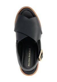 Sandalo in pelle nera con cinturini incrociati, una fibbia dorata come accento e una suola marrone chiaro. La vista dall'alto mostra una texture liscia e un design minimal.