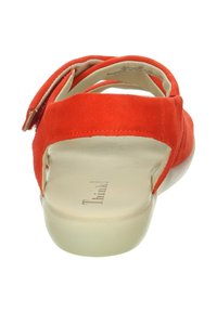 Rote Wildleder-Sandale mit einem Fersenriemen und einer gepolsterten beigen Innensohle. Sie verfügt über eine abgerundete Zehenpartie und einen strukturierten Absatz für zusätzlichen Halt.