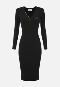 Vestito nero a coste con scollo a V, maniche lunghe e dettagli con bottoni dorati. Presenta una tasca sul petto. Silhouette aderente, design al ginocchio.