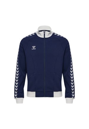 Granatowa sportowa kurtka na całej długości suwaka z białym kołnierzem, mankietami, dolnym wykończeniem oraz paskami w kształcie szewronu na rękawach. Dwie przednie kieszenie.