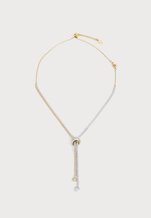 Delicate tweekleurige halsketting van goud en zilver met een geknoopte midden en twee hangende strengen die elk eindigen in een kleine ronde heldere edelsteen.