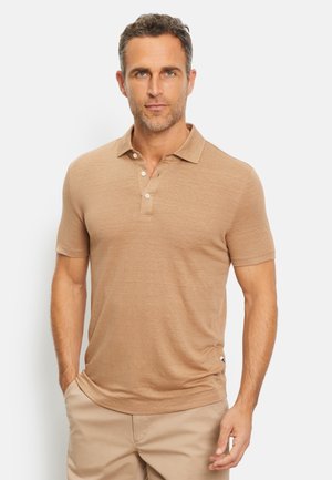 Short-sleeve polo shirt in light tan, made of soft fabric. Features a collared neck, three-button placket, and subtle logo on the side.