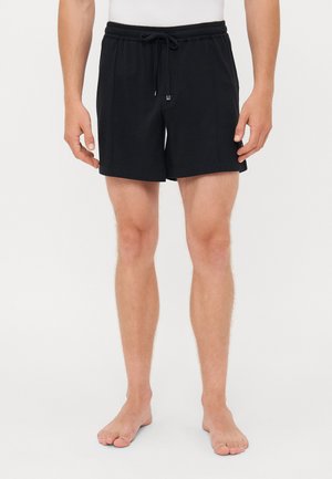 Black swim shorts made of soft fabric, featuring an elastic waistband with drawstring, and side pockets; designed with a straight cut.