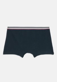 Tumši jūras zila zēnu biksītes ar strīpota elastīga jostasvieta, kurā ir pelēkas, baltas un sarkanas strīpas. Mīksta auduma ar gludu tekstūru.