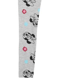 Leggings grigi con una stampa a tema di personaggi dei cartoni animati in bianco e nero, accentuati da motivi floreali rosa e blu.