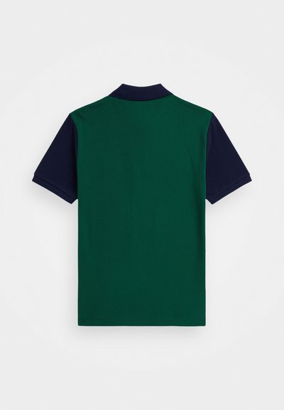 Camiseta polo verde e azul-marinho com um design bicolor. Manga curta, com colarinho. Textura suave, feita de um tecido leve.
