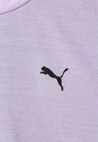 Light purple fabric with a smooth texture featuring a black leaping Puma logo as a notable detail. Round neckline with subtle stitching.